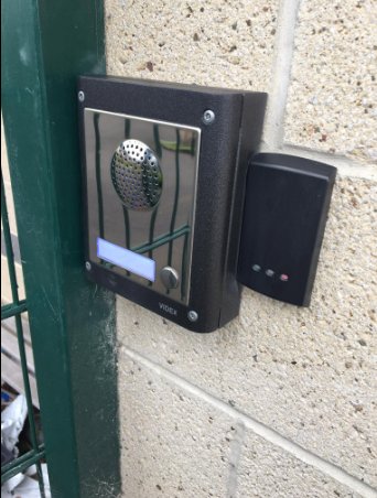 A door entry intercom with a card reader beside it, fitted at a gate post