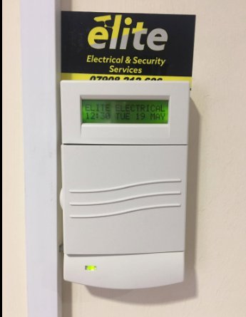 An alarm keypad showing Elite Electrical on its screen